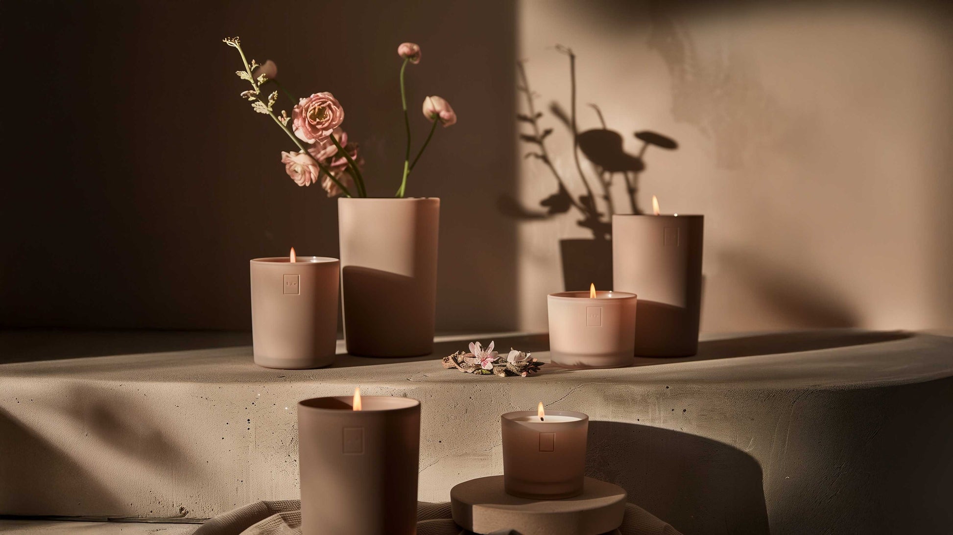 Premium wellness candle collection lifestyle photo - botanical arrangements and warm lighting